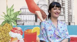 La diseñadora Lara Lars junto al cartel de Veranos de la Villa 2021