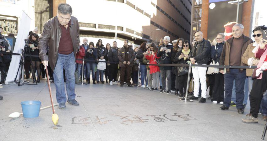 Una perfomance de caligrafía tradicional china efímera sobre el asfalto de Callao.